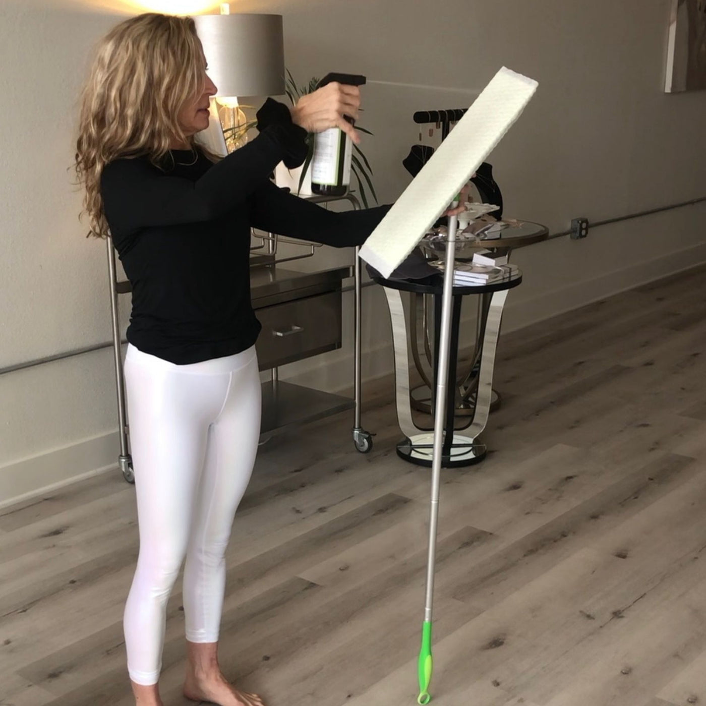 Yoga instructor spraying Clove Cinnamon Vanilla Cleaner on mop, safe and effective natural all-purpose cleaner.