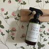 Lavender Vanilla All Purpose Cleaner bottle hanging on wooden know, safe natural cleaner for everyday use.