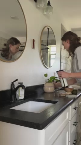 Video of mom spraying Clove Cinnamon Vanilla Cleaner on bathroom countertop and mirrors, safe and effective natural all-purpose cleaner.