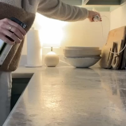 video of mom spraying Red's Gone Green All Purpose Cleaner Spray onto a granite countertop