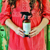 photo of lady wearing a red dress and holding a Red's Gone Green all natural cleaner